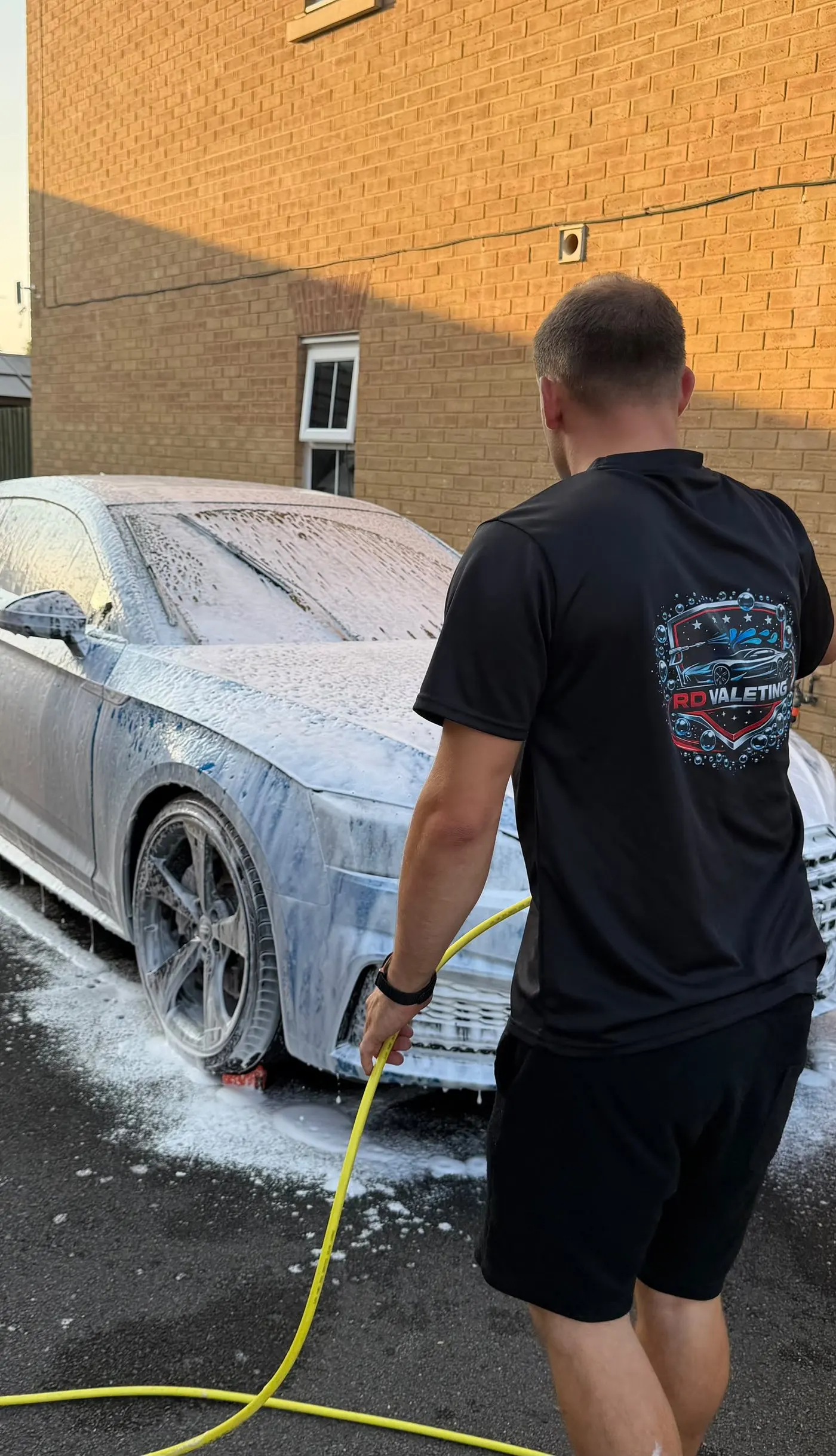 Rhys of RD Valeting applying snow foam to an Audi S5 on a customer driveway in Swindon
